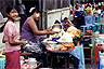 Two food vendors protect their faces from sunburn with thanakha paste