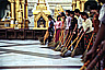 A row of volunteers sweeps the floor of Shwedagon Paya